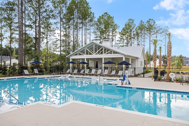 pool with a patio and fence