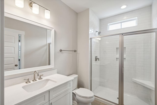 full bath with vanity, toilet, and a shower stall