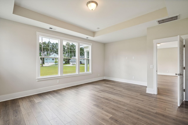 unfurnished room with visible vents, baseboards, and wood finished floors