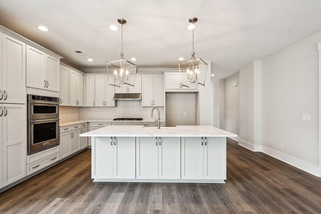 kitchen with visible vents, stainless steel double oven, dark wood-style flooring, a sink, and backsplash