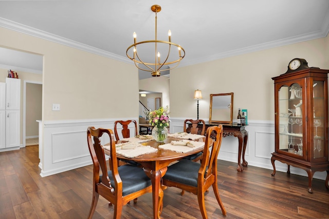 dining area featuring dark wood-type flooring, an inviting chandelier, ornamental molding, and wainscoting