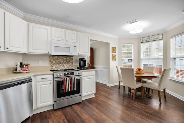 kitchen with dark wood-type flooring, a wealth of natural light, visible vents, and appliances with stainless steel finishes