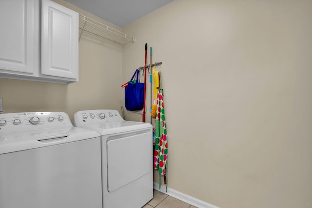 laundry room featuring light tile patterned floors, baseboards, cabinet space, and washer and clothes dryer