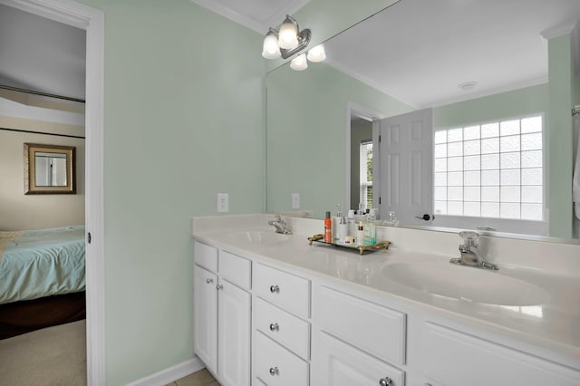 ensuite bathroom with crown molding, a healthy amount of sunlight, and a sink