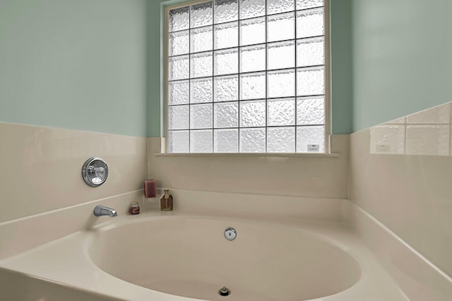 bathroom featuring a garden tub and a wealth of natural light