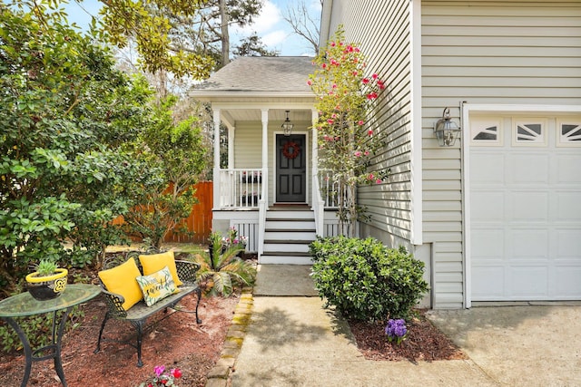 view of exterior entry featuring a garage and covered porch