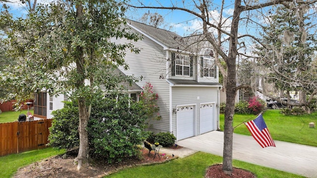 view of front of home with concrete driveway, an attached garage, fence, and a front yard