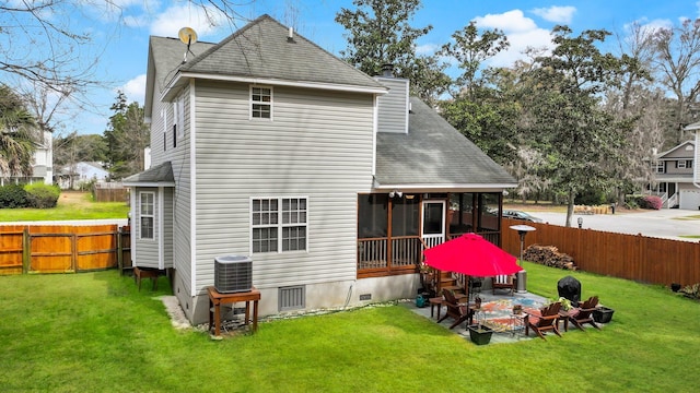 rear view of house featuring a patio area, a lawn, a sunroom, and roof with shingles