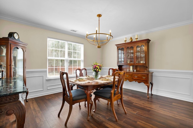 dining room featuring an inviting chandelier, wainscoting, dark wood-type flooring, and ornamental molding