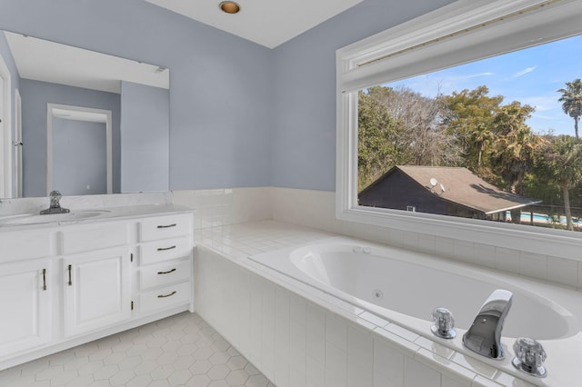 bathroom with a jetted tub, tile patterned flooring, and vanity