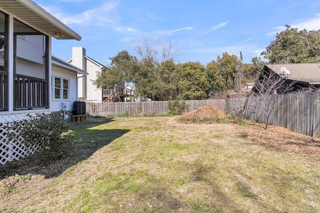 view of yard featuring central AC and fence private yard