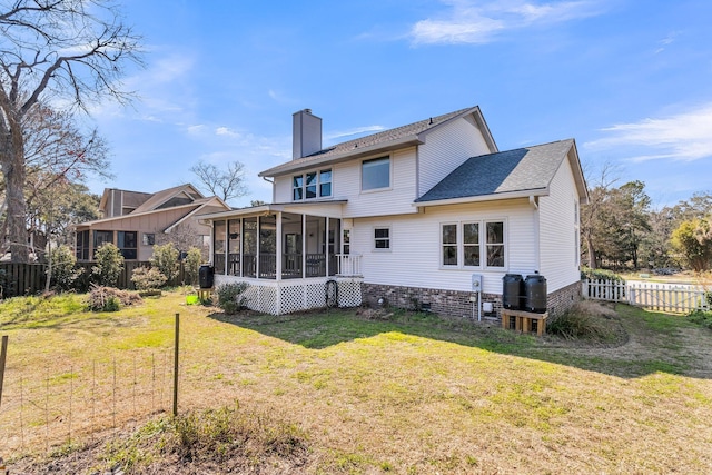 back of property with a yard, a sunroom, fence, and a chimney