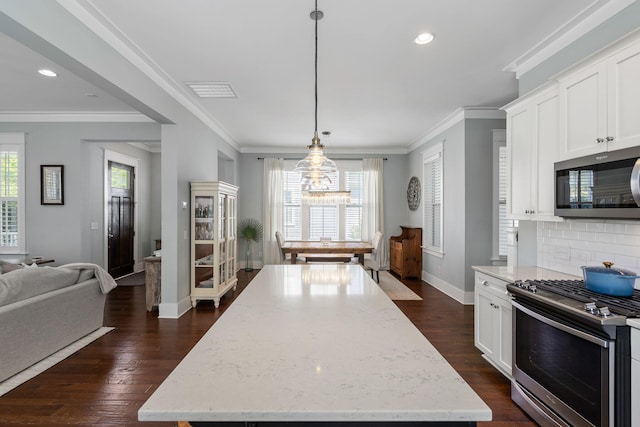 kitchen with white cabinetry, hanging light fixtures, stainless steel appliances, and light stone countertops