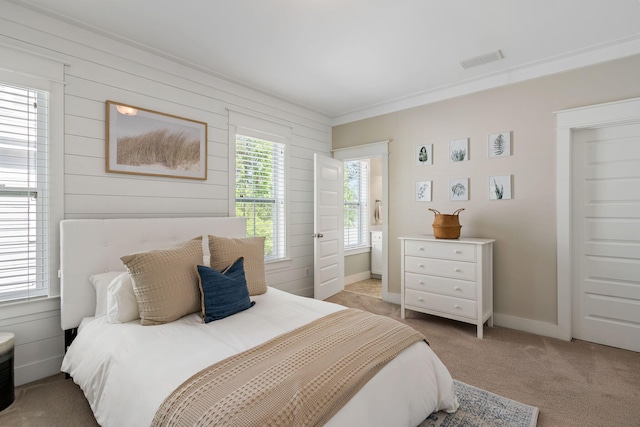 bedroom featuring light carpet and wood walls