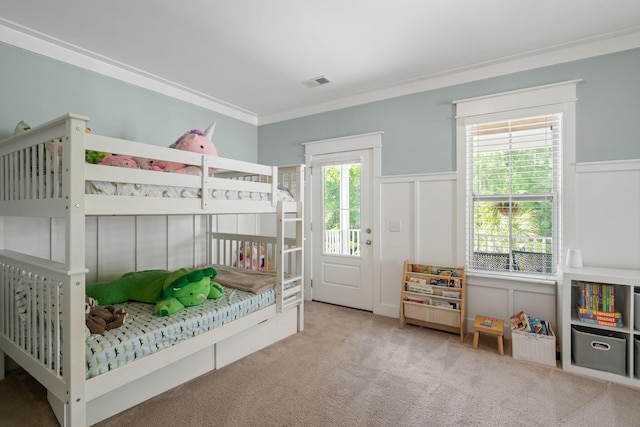 carpeted bedroom with multiple windows, crown molding, and access to outside