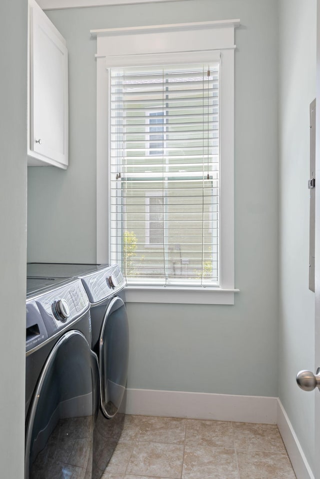 laundry area featuring cabinets, plenty of natural light, light tile patterned floors, and washer and clothes dryer