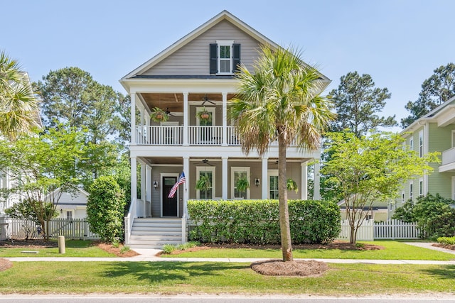 view of front of house featuring a balcony, a front yard, and ceiling fan