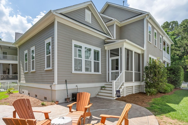 back of property with a sunroom and a patio area