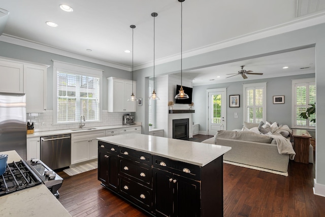 kitchen with white cabinetry, sink, hanging light fixtures, and appliances with stainless steel finishes