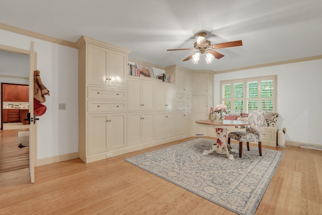 dining space featuring ceiling fan, crown molding, and light hardwood / wood-style flooring