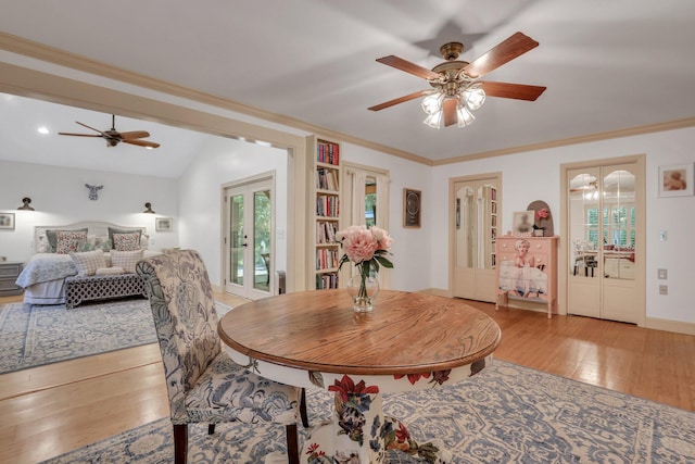 dining room with crown molding, french doors, vaulted ceiling, and light wood-type flooring