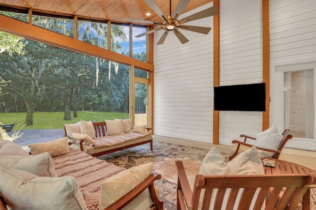 sunroom with ceiling fan, wood ceiling, and lofted ceiling