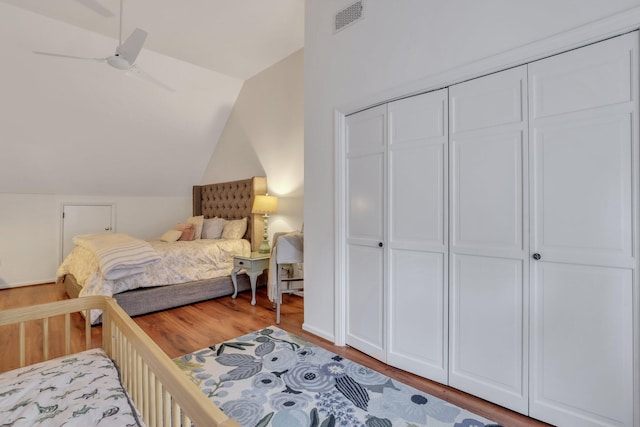 bedroom featuring ceiling fan, a closet, hardwood / wood-style floors, and lofted ceiling