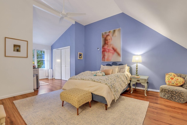 bedroom featuring ceiling fan, a closet, wood-type flooring, and vaulted ceiling