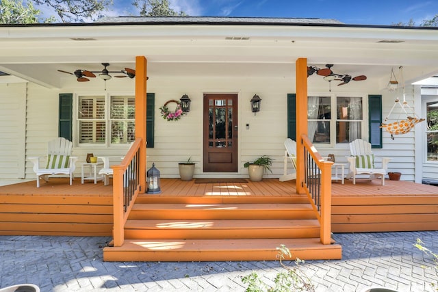 view of exterior entry featuring ceiling fan and a porch