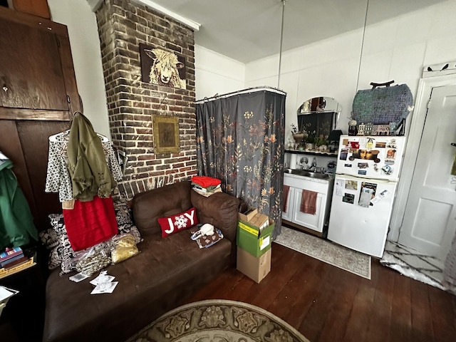 living room with brick wall and hardwood / wood-style floors