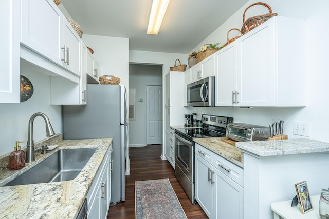 kitchen featuring white cabinetry, stainless steel appliances, sink, and light stone counters