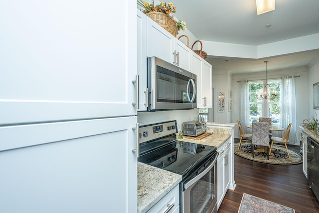 kitchen with white cabinetry, light stone counters, hanging light fixtures, appliances with stainless steel finishes, and dark hardwood / wood-style flooring