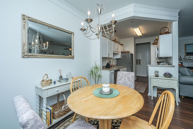 dining space featuring a notable chandelier, dark wood-type flooring, ornamental molding, and sink