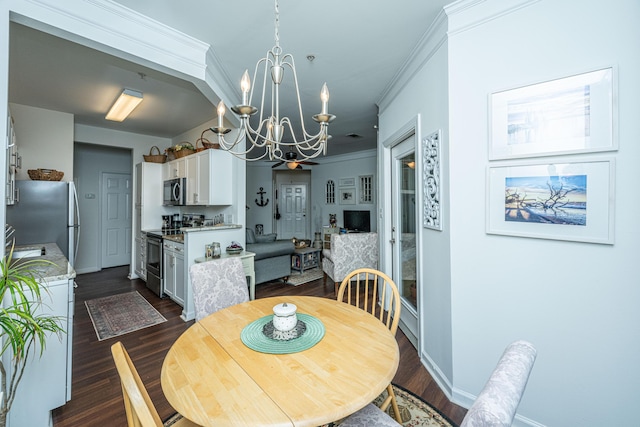 dining area featuring dark hardwood / wood-style flooring, crown molding, and a chandelier