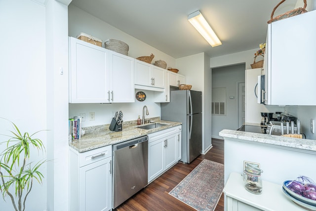 kitchen featuring light stone counters, sink, white cabinets, and appliances with stainless steel finishes