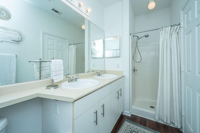 bathroom featuring hardwood / wood-style flooring, vanity, and curtained shower