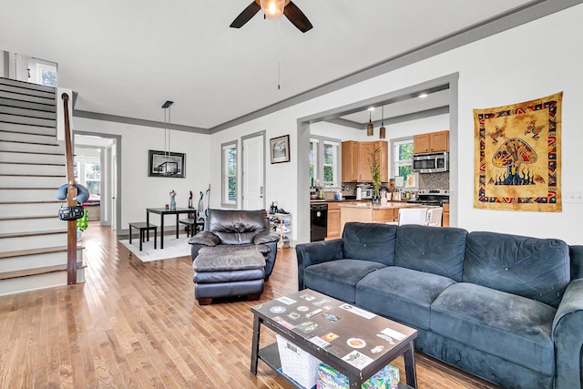 living room with crown molding, light hardwood / wood-style flooring, and ceiling fan