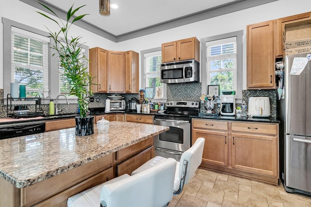 kitchen with appliances with stainless steel finishes, backsplash, sink, and light stone countertops