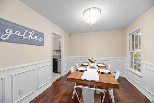 105 Spring St, Summerville, SC 29485 - dining space with dark wood-type flooring, wainscoting, a textured ceiling, a chandelier, and a decorative wall