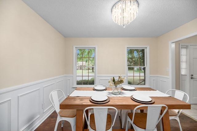 105 Spring St, Summerville, SC 29485 - dining room featuring a textured ceiling, a chandelier, wainscoting, and a decorative wall