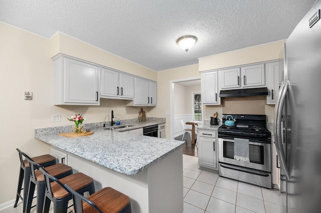 105 Spring St, Summerville, SC 29485 - kitchen featuring stainless steel appliances, under cabinet range hood, a peninsula, a breakfast bar, and light tile patterned flooring