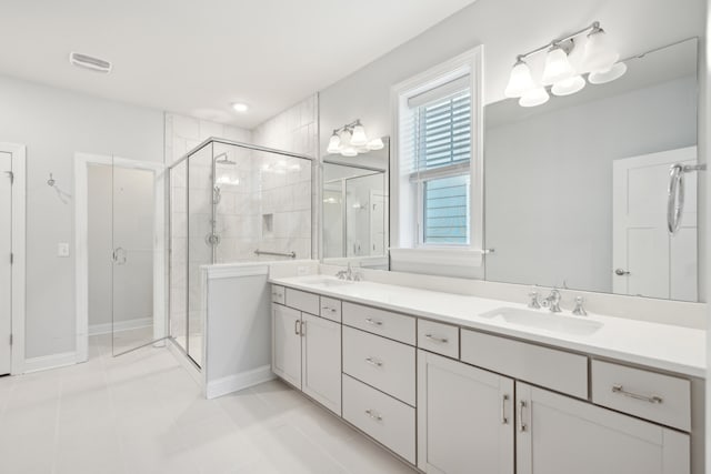 bathroom with tile patterned floors, a shower with door, and vanity