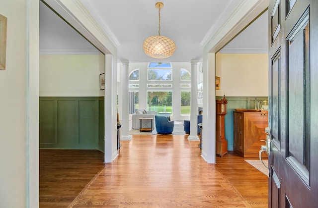 4227 Sawgrass Dr, North Charleston, SC 29420 - entrance foyer with ornate columns, crown molding, a decorative wall, wood finished floors, and a wainscoted wall
