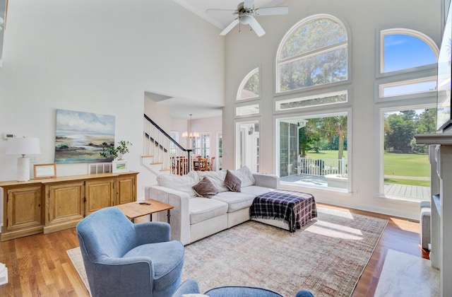 4227 Sawgrass Dr, North Charleston, SC 29420 - living area with stairway, a towering ceiling, light wood-style flooring, ceiling fan, and a chandelier
