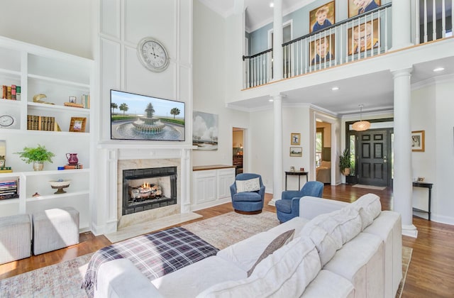 4227 Sawgrass Dr, North Charleston, SC 29420 - living room featuring ornate columns, crown molding, a high ceiling, wood finished floors, and a high end fireplace