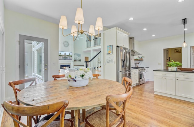 4227 Sawgrass Dr, North Charleston, SC 29420 - dining space featuring light wood finished floors, a lit fireplace, a chandelier, recessed lighting, and stairway