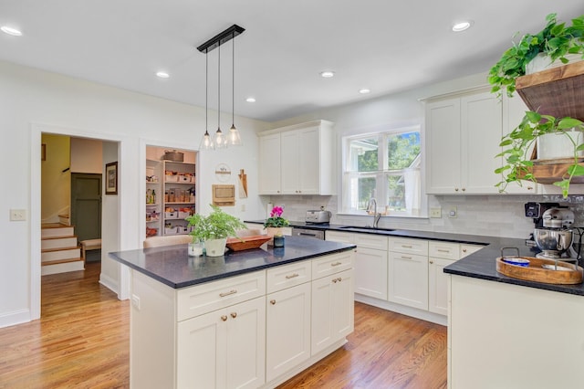 4227 Sawgrass Dr, North Charleston, SC 29420 - kitchen featuring a sink, light wood-style floors, tasteful backsplash, hanging light fixtures, and white cabinets