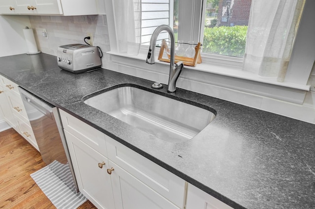 4227 Sawgrass Dr, North Charleston, SC 29420 - kitchen featuring a sink, white cabinets, decorative backsplash, wood finished floors, and dark stone counters