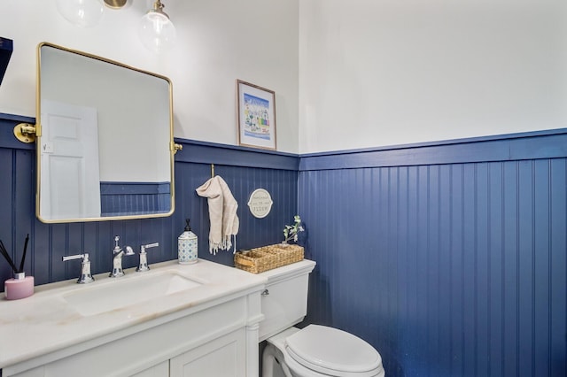 4227 Sawgrass Dr, North Charleston, SC 29420 - half bathroom featuring toilet, vanity, and a wainscoted wall