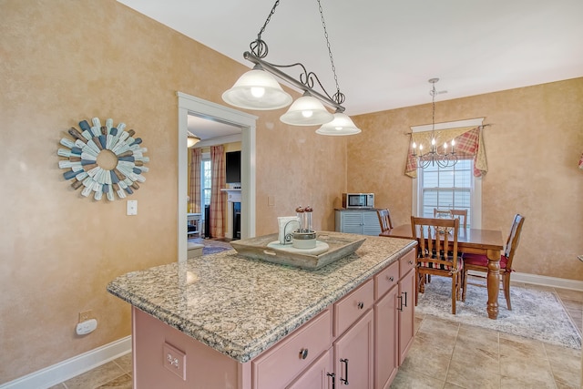 kitchen with a center island, a chandelier, and decorative light fixtures